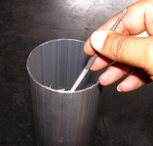 Removing the sharp burrs from the freshly cut main tube with small files.